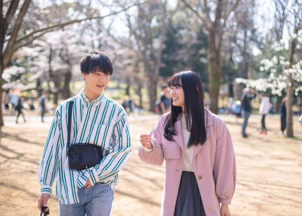 istock Young couple walking in public park in sunny day 1214375021
