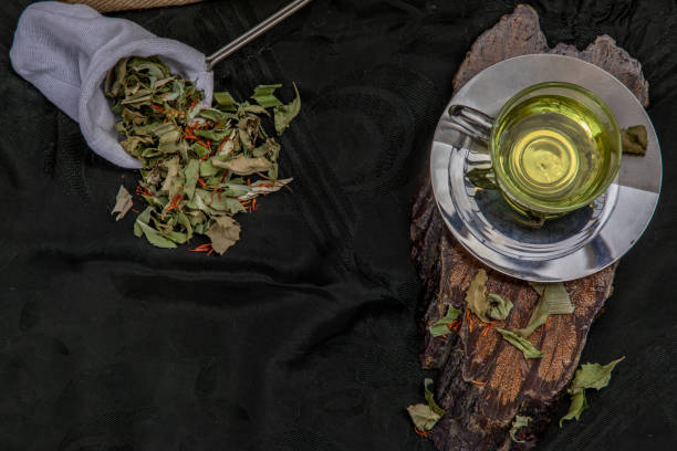 A Cup of pandan leaf tea, indian marsh fleabane plant leaves with Safflower dried (Saffron substitute) at dark background. A Cup of pandan leaf tea, indian marsh fleabane plant leaves with Safflower dried (Saffron substitute) at dark background. Thai herbal plant and healthy drinks concept. Selective focus. substitute for saffron stock pictures, royalty-free photos & images
