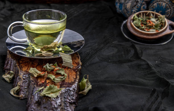 A Cup of pandan leaf tea, indian marsh fleabane plant leaves with Safflower dried (Saffron substitute) at dark background. A Cup of pandan leaf tea, indian marsh fleabane plant leaves with Safflower dried (Saffron substitute) at dark background. Thai herbal plant and healthy drinks concept. Selective focus. substitute for saffron stock pictures, royalty-free photos & images