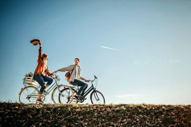 coppia rilassante al sole con bicicletta nella natura - bicycle ride foto e immagini stock