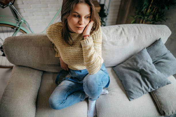 istock Young women sitting on sofa 1214379800