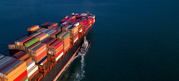 Container cargo ship business commercial trade import export logistic transportation container box oversea worldwide by container vessel boat freight shipping maritime with tugboat.