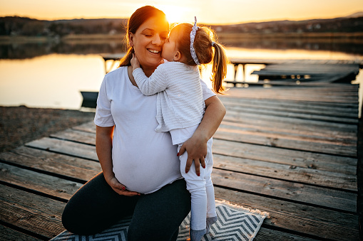 Pregnant women doing yoga with her daughter