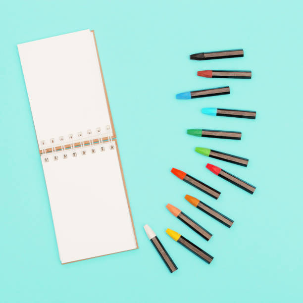 istock Top view of colored pastel crayons and notebook on spring for sketches. Set of multicolored chalks for creativity. Design background social media. 1214385013