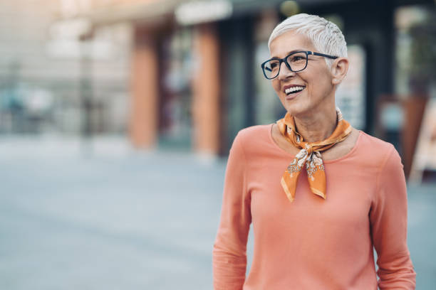 Smiling mature woman with short hair and eyeglasses Senior woman outdoors in the city shorthair stock pictures, royalty-free photos & images