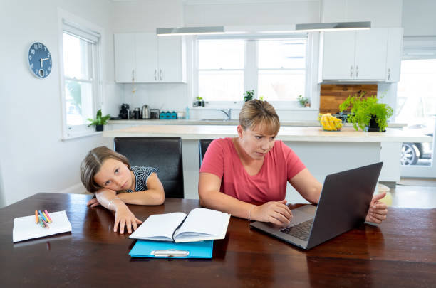 istock Coronavirus Outbreak schools and offices closing. Stressed mother coping with remote work and bored daughter. COVID-19 shutdowns and quarantines forces parents to work from home and homeschooling. 1214388954