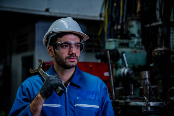 istock The Industry engineering wear safety uniform hold wrench standing on control operating machine factory. 1214390550