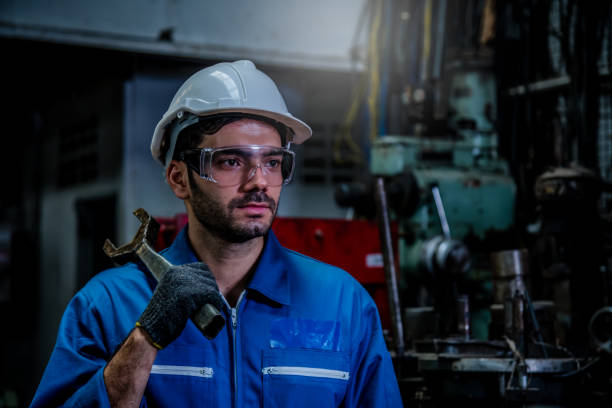 istock The Industry engineering wear safety uniform hold wrench standing on control operating machine factory. 1214390667