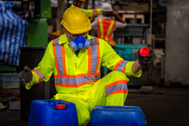 un'industria ingegnere che indossa uniformi di sicurezza, guanti neri e maschera antigas sotto controllo serbatoio chimico nel lavoro di fabbrica dell'industria. - half tank foto e immagini stock