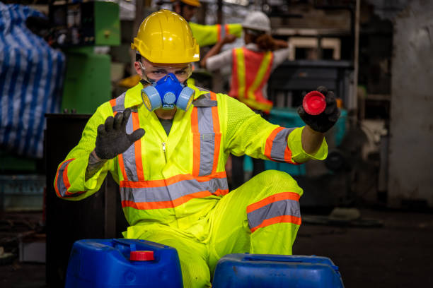 un'industria ingegnere che indossa uniformi di sicurezza, guanti neri e maschera antigas sotto controllo serbatoio chimico nel lavoro di fabbrica dell'industria. - half tank foto e immagini stock