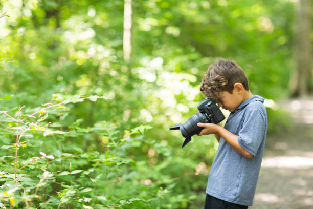 istock Young boy taking photo in the forest. 1214391362