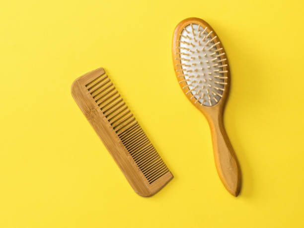 istock Two wooden combs on a yellow background. 1214391420
