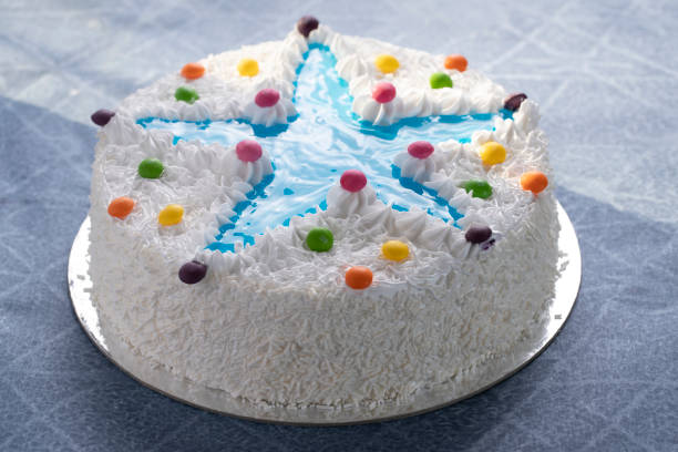 Fresh cream cake with blue star with whipped cream and m&ms chocolates as topping. Homemade romantic cake ideal for Valentine’s Day, bakery cakes with piped icing