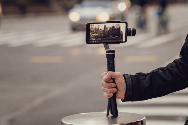 istock Man taking photos and videos with phone and stabilizer 1214400070