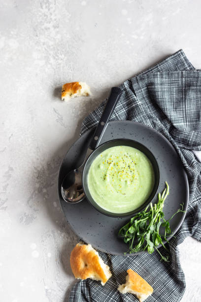 アボカドとほうれん草のビーガンクリームスープにマイクログリーンとパンを添えて。ダイエット食品の概念。ベジタリアンとビーガンの食べ物。 - soup zucchini spinach cream ストックフォトと画像