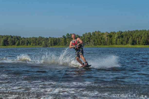 istock Tense man wakeboarding in a lake and pulled by a boat 1214410828