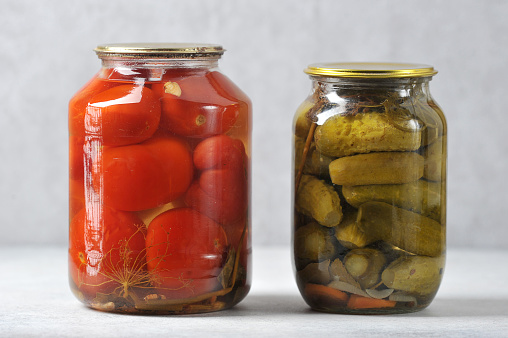 glass jar with an iron lid with canned red tomatoes and cucumbers - canned tomatoes and cucumbers