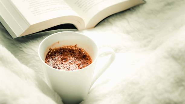 Coffee mugs and books on the bed selective focus