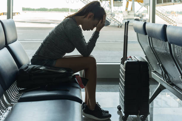 un passeggero in attesa al terminal dell'aeroporto si è stressato a stanco. - beached foto e immagini stock