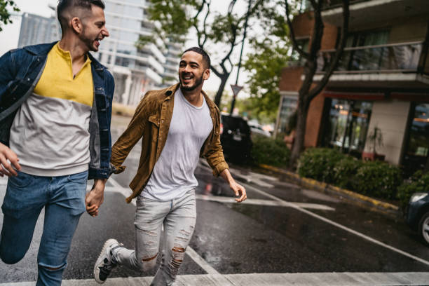 istock Gay couple walking in the rain 1214421930