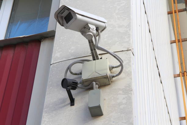 istock Surveillance camera mounted on wall of house 1214422034