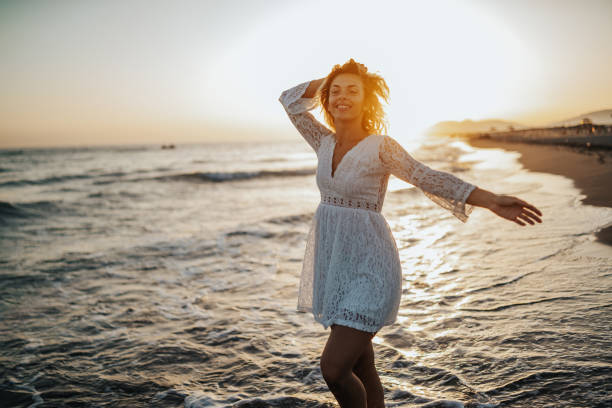 istock Happy woman dancing on beach 1214424515
