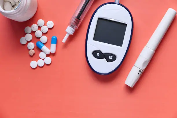 Glucometer, blood sugar measurement for diabetes, pills and stethoscope.