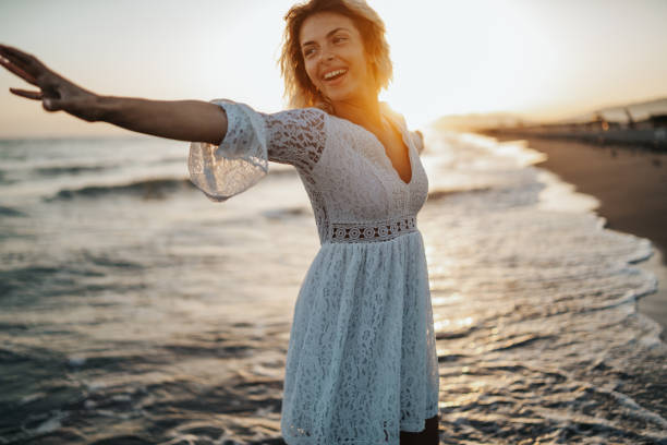 istock Happy woman dancing on beach 1214424666