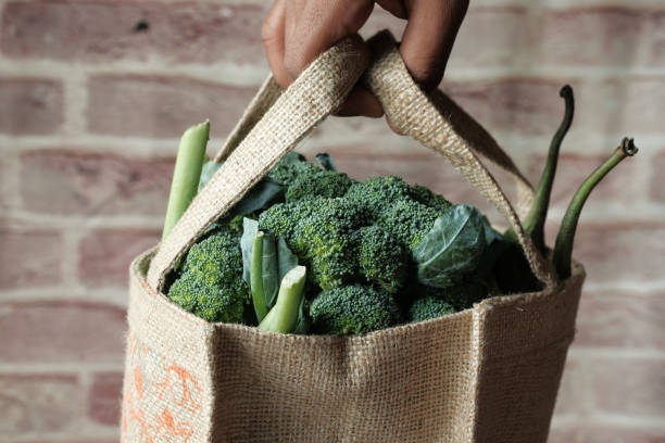 istock Man's hand hold eco friendly reusable bag with various fresh organic vegetables 1214426591