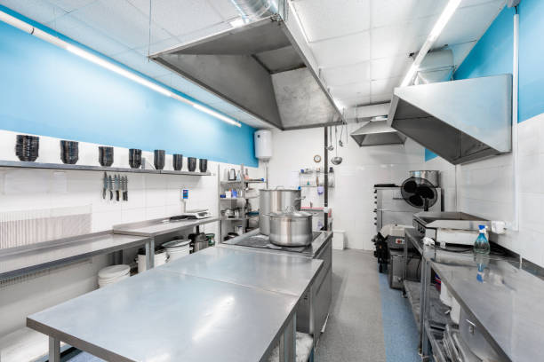 istock Work surface and kitchen equipment in professional kitchen. Cooking with preparation tables, pans, pots, stoves. 1214428455