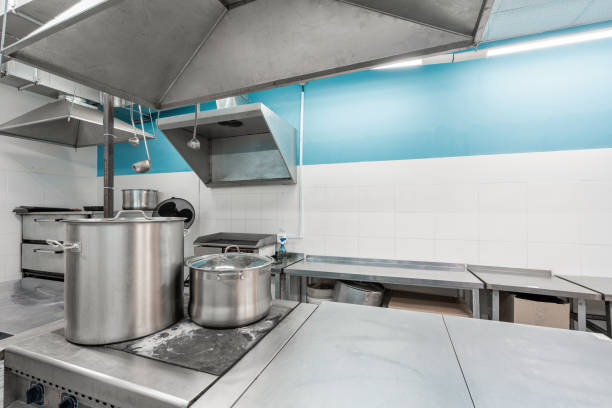 istock Work surface and kitchen equipment in professional kitchen. Cooking with preparation tables, pans, pots, stoves. 1214428487