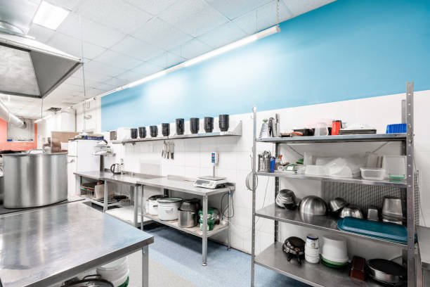 istock Work surface and kitchen equipment in professional kitchen. Cooking with preparation tables, pans, pots, stoves. 1214428510
