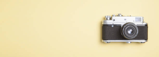 istock Old camera on yellow background. Space for your text 1214429495