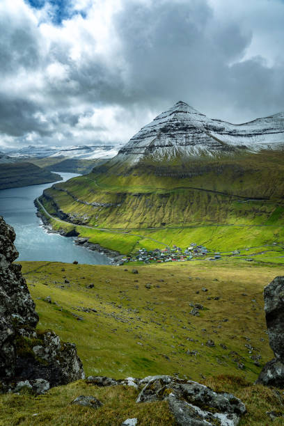 Dramatic landscape of Faroe Islands with snow-covered mountains and deep narrow fjords. stock photo