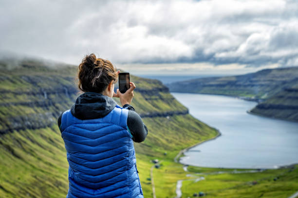 Female traveler admiring dramatic landscape in Faroe Islands. stock photo