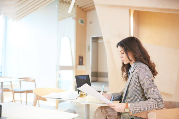 istock Elegant Young Woman Working in Cafe 1214432918