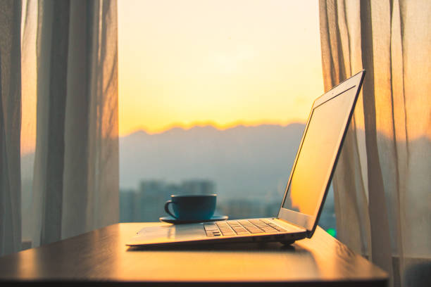 istock Laptop on desk with window sunset 1214432992
