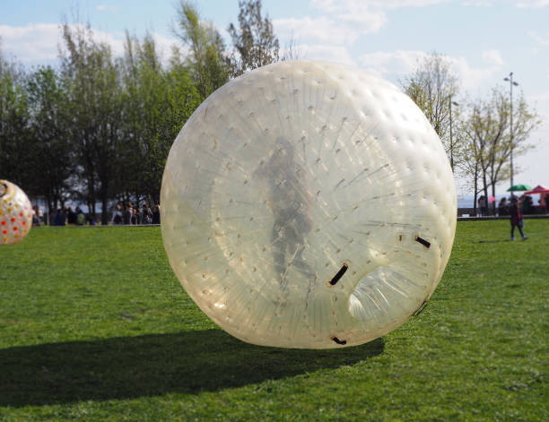 A girl is rolling down in a giant bubble ball for outdoor inflatable games A girl is rolling down in a giant bubble ball for outdoor inflatable games. St. Petersburg, Russia. 05/01/2019. zorbing stock pictures, royalty-free photos & images