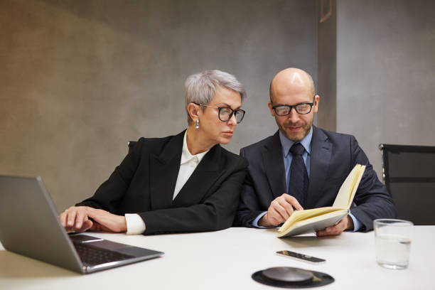 istock Two Mature Business People Working 1214434049