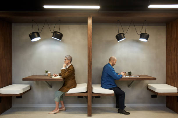 moderne erwachsene in separaten cafe booths - rücken an rücken stock-fotos und bilder