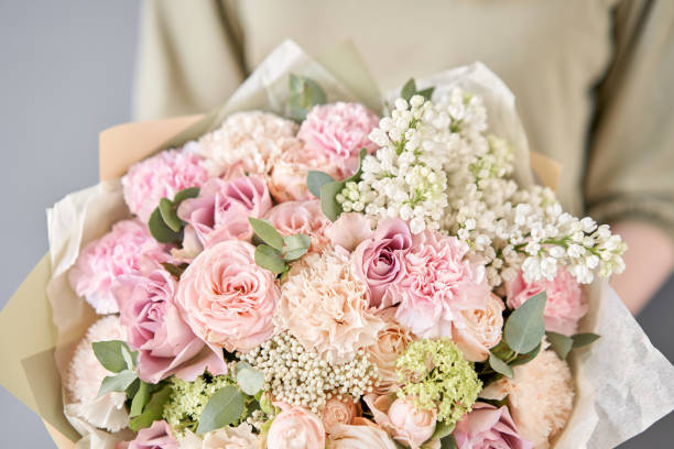 Small flower shop and Flowers delivery. Beautiful bouquet of mixed flowers in woman hands. Work of the florist at a flower shop. Delivery fresh cut flower. European floral shop. Two Beautiful bouquets of mixed flowers in womans hands. the work of the florist at a flower shop. Delivery fresh cut flower flower arrangement bouquet variation flower stock pictures, royalty-free photos & images