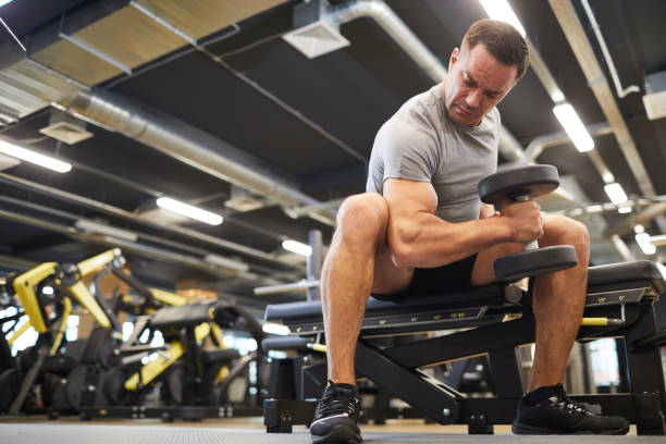 istock Muscular Man Lifting Weights in Gym 1214435305