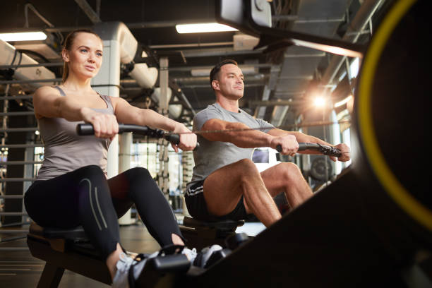 istock Sportive Couple Using Exercise Machine in Gym 1214435335
