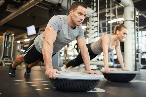 istock Sportive Couple Doing Balance Exercises in Gym 1214435406