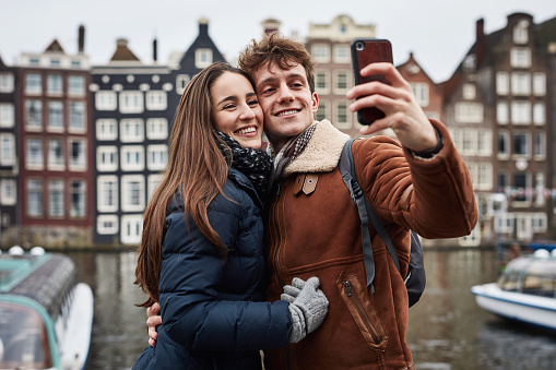 Shot of an affectionate couple taking a selfie while exploring a foreign city