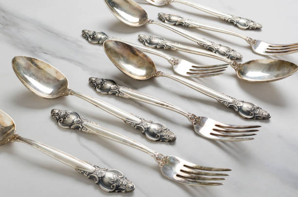 istock Closeup of vintage spoons and fork with decorative handles on the white table 1214437066