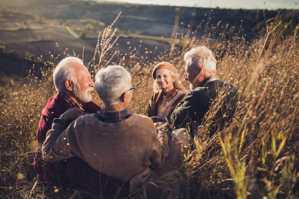 istock Happy seniors talking during autumn day in tall grass. 1214437255