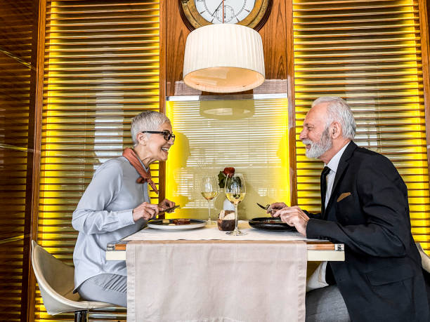 istock Elegant elderly couple fine dining in a cozy restaurant 1214440812