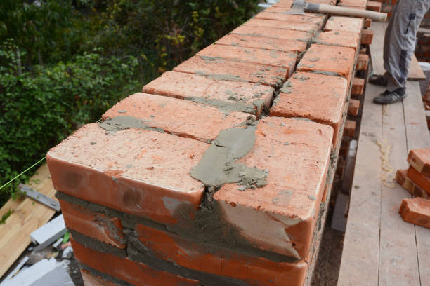 istock Bricklaying brick wall on house construction site. 1214443763