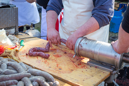 Process of making homemade sausages in natural casing. Filling the stuffing with homemade sausage.